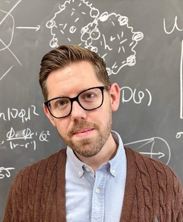 Portrait of node director Prof. David Limmer in front of blackboard