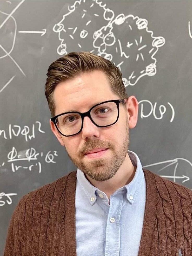 Portrait of node director Prof. David Limmer in front of blackboard